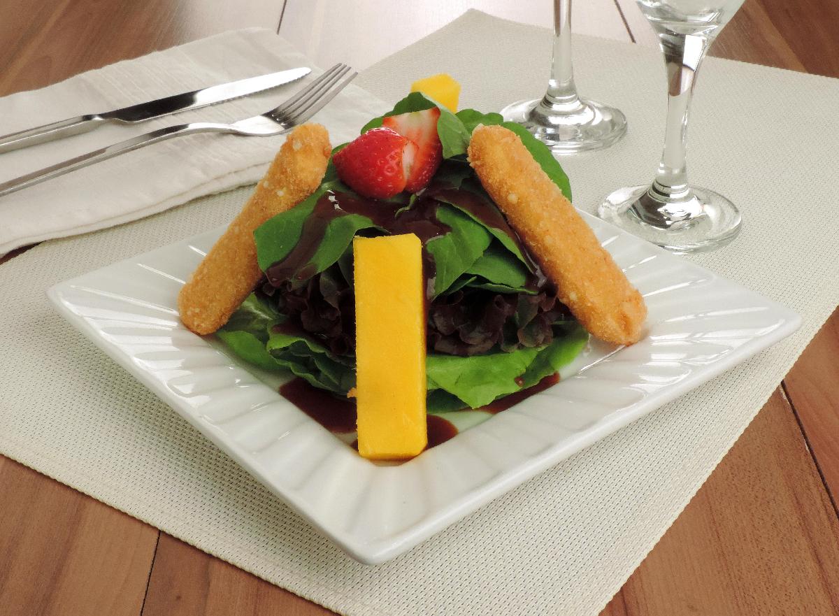 Salada de folhas verdes com queijo brie empanado servidos em prato branco