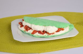 Tapioca verde com creme de ricota e tomate seco servida em prato branco