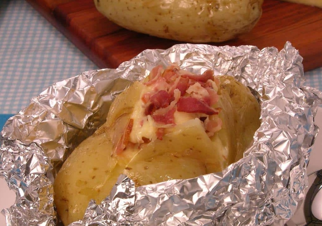 Batata recheada com bacon e queijo embrulhada com papel metalizado