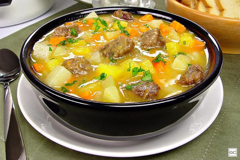 Sopa cremosa de legumes servida em pote preto