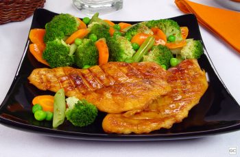 Peito de frango com brócolis e cenoura servido em prato preto