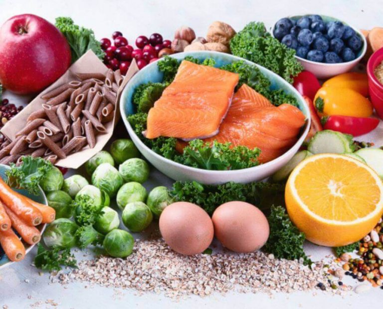 Frutas, legumes, salmão e outros alimentos distribuídos em mesa