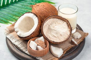 Coco, farinha de coco e leite de coco em tábua de madeira